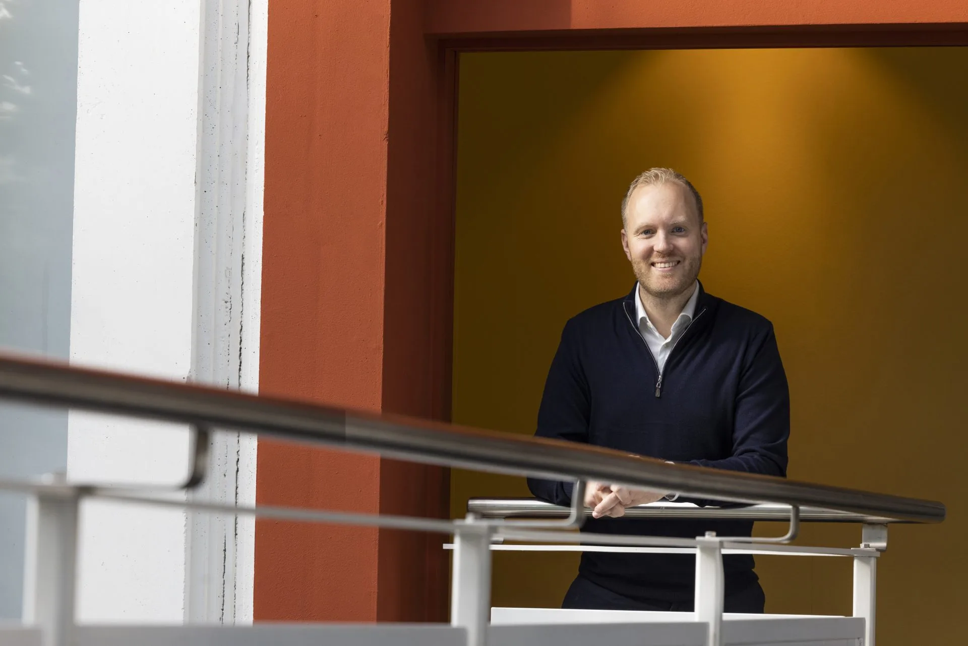 Jesper Hebnes, daglig leder i Zigma ERP, står i et kontorlandskap og smiler mot kamera